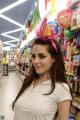 A woman standing in front of a store filled with balloons.