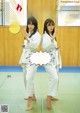 A couple of women standing on top of a green mat.