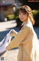 A woman in a striped shirt is holding a blanket.