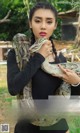 A woman holding a large snake in her hands.