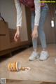 A woman standing on the floor next to a cup of coffee.