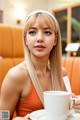 A woman sitting at a table with a cup of coffee.