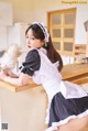 a woman in a maid outfit is posing for the camera