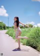 A woman in a bikini standing on the side of a road.