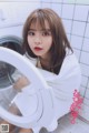 A woman sitting in front of a washing machine.