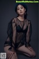 A woman in a black lingerie and a blue hat.