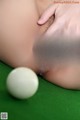 A woman is playing pool with a white ball.